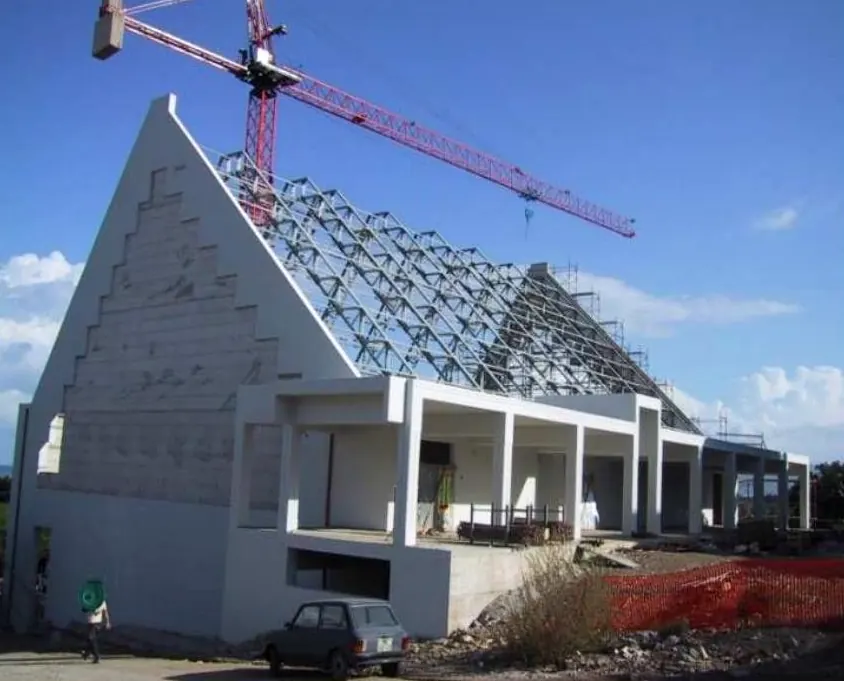Cantiere di un complesso religioso con struttura in acciaio della copertura e gru a torre